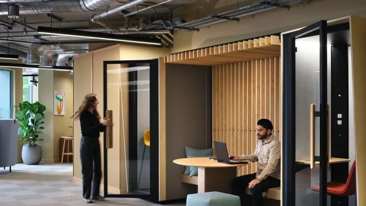 Orangebox Be my guest® phone booth swith 2 persons around in an office environment