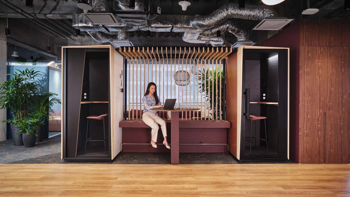 Orangebox Be my guest® phone booth with canopy and wall in-between in an open space environment
