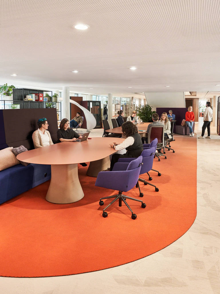 People seated around a conference table in an open space at the Munich LINC