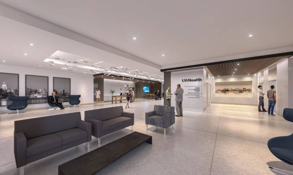 Picture of a medical lobby area with couches, tables and plant life.