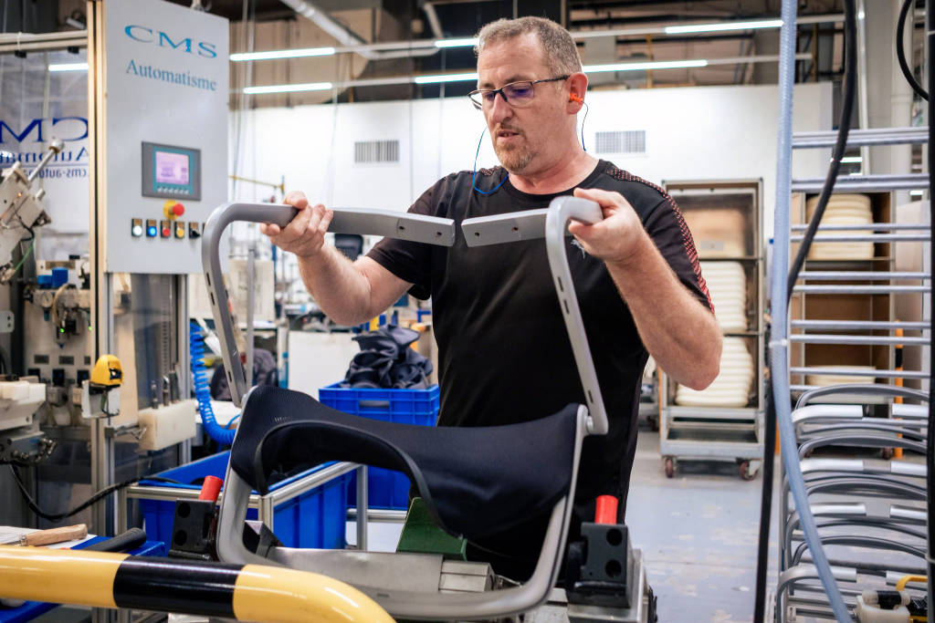 Man reassembling chair in factory