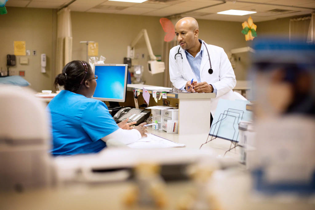 Nurse talking to doctor at nurse station