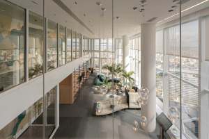 Oficina moderna con espacios abiertos y colaborativos, mobiliario de oficina y elementos decorativos.