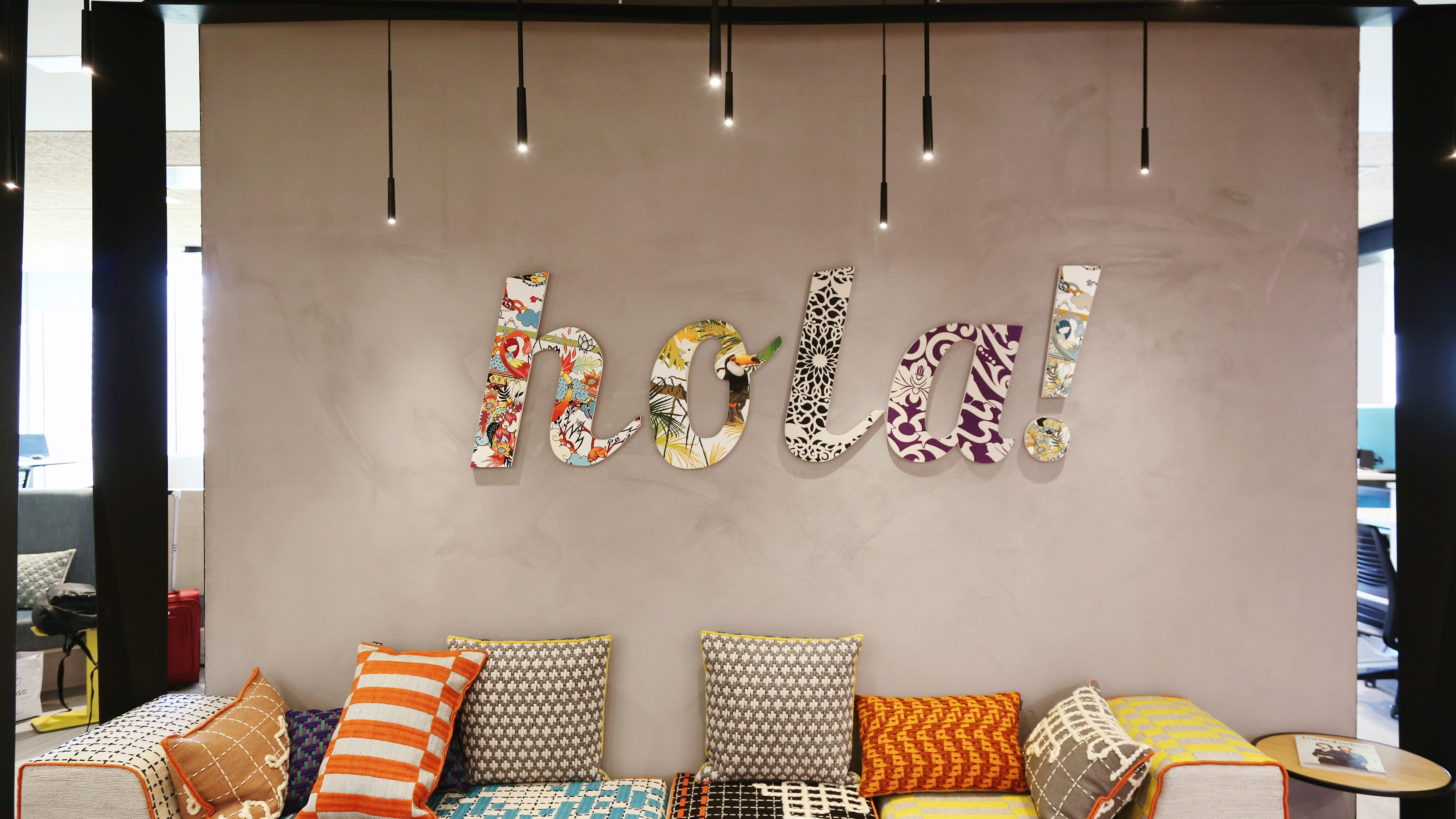 Gray wall with the word "hola" in the hanging in the middle