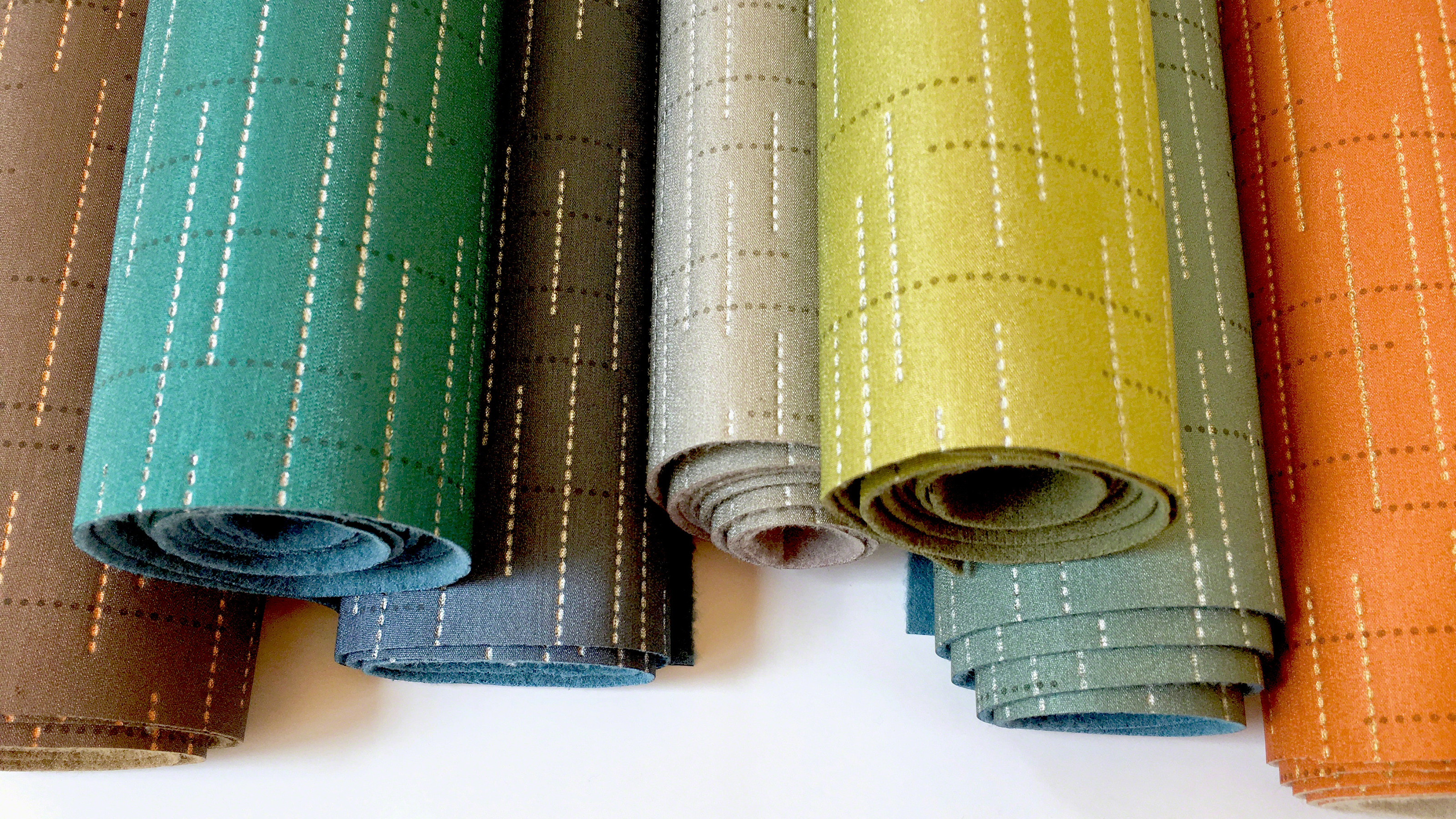 7 rolls of patterned upholstery in a variety of colors